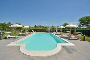a swimming pool with chairs and umbrellas at Casa Il Pino in Cavriglia