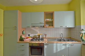 una cucina con armadi verdi e bianchi e un lavandino di Casa Il Pino a Cavriglia