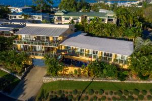 una vista aérea de una casa con palmeras en Sunlit Waters Studio Apartments, en Airlie Beach