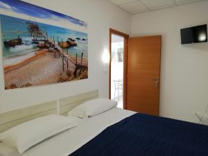 - une chambre avec un lit et une peinture murale dans l'établissement Silvi d'aMare, à Silvi Marina