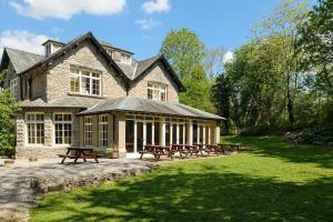 a building with picnic tables in front of it at Woodlands Hotel & Pine Lodges in Grange Over Sands