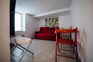 a living room with a red couch and a red chair at La Maison Golfo dei Poeti in Lerici
