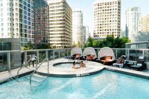 a swimming pool on top of a building with tall buildings at Hyatt Vancouver Downtown Alberni in Vancouver