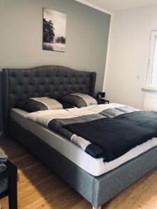 a bedroom with a large bed with a black headboard at Ferienwohnung am Berg in Bad Bergzabern
