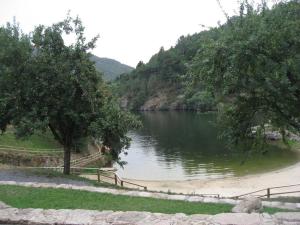 a view of a river with trees and a fence at En plena Ribera Sacra CasaCocó in Ferreira