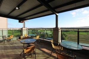 a patio with tables and chairs on a balcony at Yiren Hotel in Hengchun