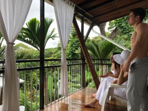eine Gruppe von Personen, die auf dem Balkon eines Resorts sitzen in der Unterkunft Ballena Dorada Lodge in Uvita