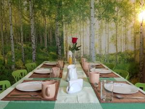 ein langer Tisch mit Platten und eine Rose im Wald in der Unterkunft Distrito Condesa Rooms and Studios in Mexiko-Stadt