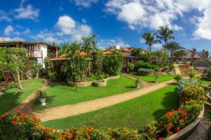 a garden in a resort with flowers and trees at Espaço Nova Era Pousada in Jericoacoara