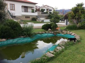 アロウカにあるQuinta da Ribeirinhaの庭の池の横に立つ犬