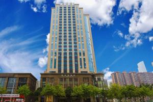 Guangzhou Victoria Hotel في قوانغتشو: مبنى طويل مع سماء زرقاء في الخلفية