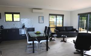 a kitchen and living room with a table and chairs at Chalet Swen Song in Napier