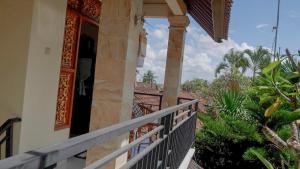 a balcony of a house with an open door at Arya Homestay in Ubud