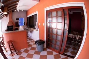 a kitchen with an orange wall and a door at Casa Temporada in Jacareí