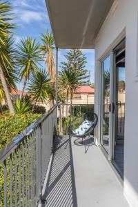 een balkon met een stoel en palmbomen bij Bay 10 - Suites and Apartments in Port Lincoln