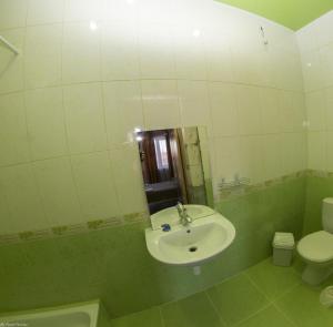 La salle de bains est pourvue d'un lavabo et de toilettes. dans l'établissement Maldives, à Vapniarka