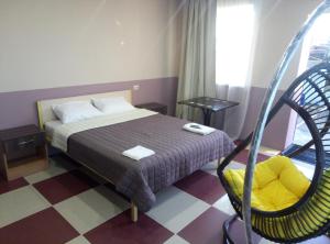 une chambre d'hôtel avec un lit et une chaise dans l'établissement Maldives, à Vapniarka
