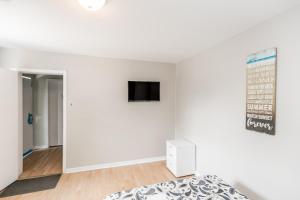 a bedroom with a bed and a tv on a wall at Beachfront at Beach1 Motel in Wasaga Beach