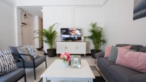 sala de estar con 2 sofás y TV en Neveu Premier Residence : Ratchada en Bangkok