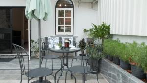 a table and chairs on a patio with plants at Neveu Premier Residence : Ratchada in Bangkok