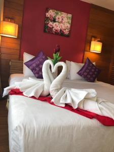 two swans made into hearts sitting on a bed at Vieng Mantra Hotel in Chiang Mai