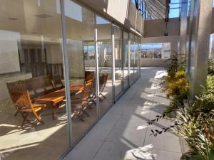 a glass extension of a building with a wooden table and benches at Cono de Arita in Salta