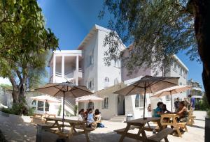 a group of people sitting at tables in front of a building at Résidence Aragon in Juan-les-Pins