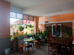 a dining room with a table and chairs and plants at Baanpak Sam Anong in Hua Hin
