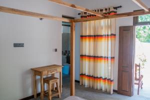 a room with a colorful curtain and a wooden table at Hilltop House in Arugam Bay