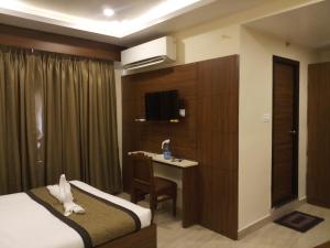 une chambre d'hôtel avec un lit et un bureau dans l'établissement Hotel White Boutique, à Pondichéry