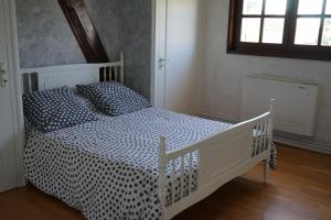 a bedroom with a white bed with a black and white comforter at Les Roses de Rita in Boisset-lès-Montrond +35 photos