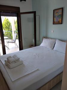 a bedroom with a large white bed with towels on it at Angelo Studios in Nikiti