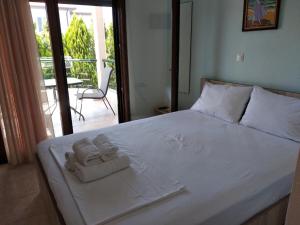 a bedroom with two towels on a bed with a balcony at Angelo Studios in Nikiti