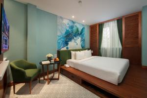 una camera con letto, scrivania e sedia di Hanoi La Selva Central Hotel & Spa a Hanoi