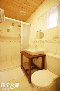 uma casa de banho com um WC branco e um lavatório. em House of Ahan em Meishan