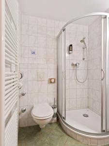 a small bathroom with a toilet and a shower at Hotel Bohemia in Berlin