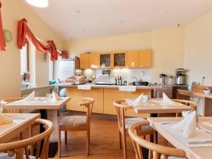 a dining room with tables and a kitchen at Hotel Bohemia in Berlin