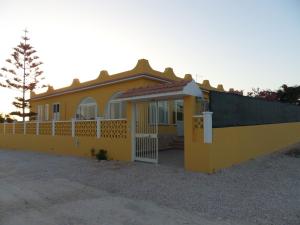 a yellow house with a gate and a fence at Casa Venere in Lampedusa