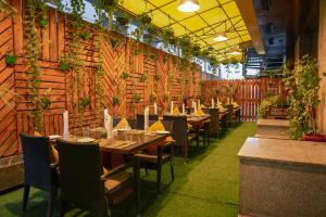 a restaurant with wooden walls and tables and chairs at Hotel Winway in Indore