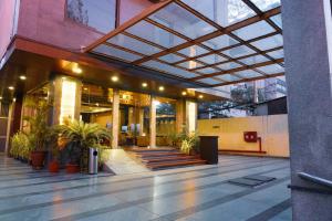 un hall d'un bâtiment avec des plantes en pot dans l'établissement Hotel Winway, à Indore