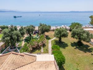 Blick auf einen Strand mit Bäumen und das Wasser in der Unterkunft Barbati Beach Holiday Apartment, Corfu,Greece in Barbati