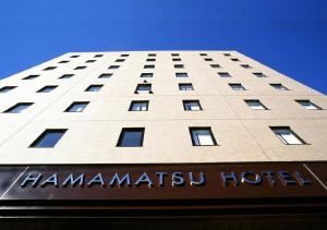 a tall white building with ahmmarkiya hotel sign in front at Hamamatsu Hotel in Hamamatsu