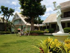 a statue in a yard next to a house at Scent of Sukhothai Resort in Sukhothai