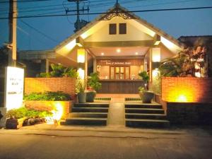 a house with stairs in front of it at night at Scent of Sukhothai Resort in Sukhothai