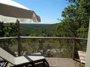 a table and an umbrella on a balcony with a view at Les Hauts d'Albas in Albas