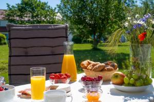 a table with breakfast food and orange juice and fruit at Feriendorf am Bakenberg in Dranske
