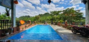 une grande piscine bleue devant un immeuble dans l'établissement Phong Nha Amanda Homestay, à Phong Nha