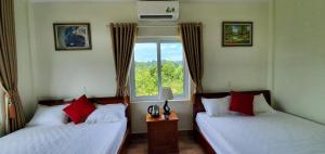 deux lits dans une chambre avec une fenêtre dans l'établissement Phong Nha Amanda Homestay, à Phong Nha 46 autres photos