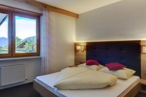 a bedroom with a bed with white sheets and red pillows at Residence Krone in Schenna +53 photos