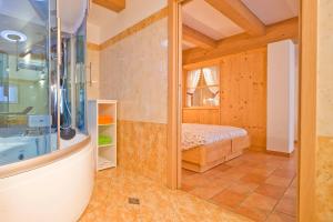a bathroom with a shower and a bed in a room at Albergo San Rocco in Peio